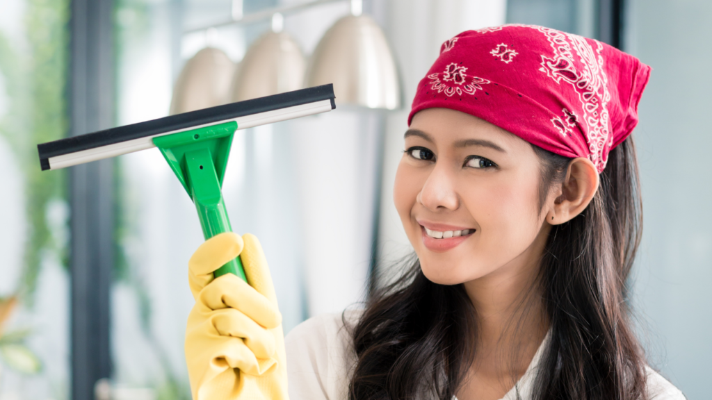 A woman holding up a squeegee