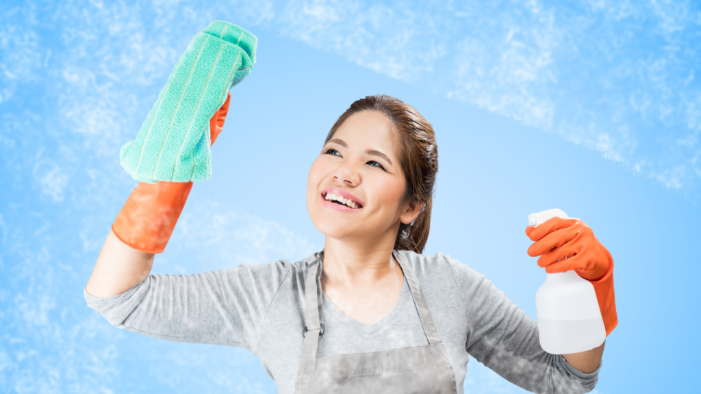 A woman spraying window with glass cleaning solution